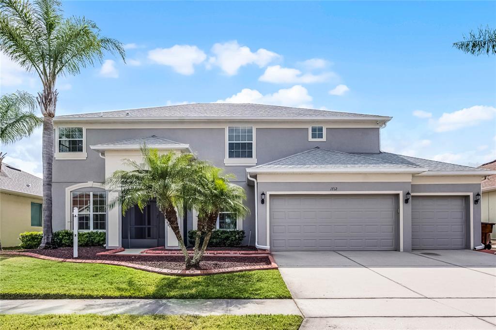1712 Boat Launch Road Kissimmee, FL 34746 - Photo 1 of 1 a front view of a house with a yard and potted plants