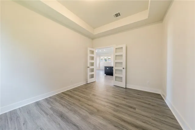 a kitchen with granite countertop a stove a sink and white cabinets