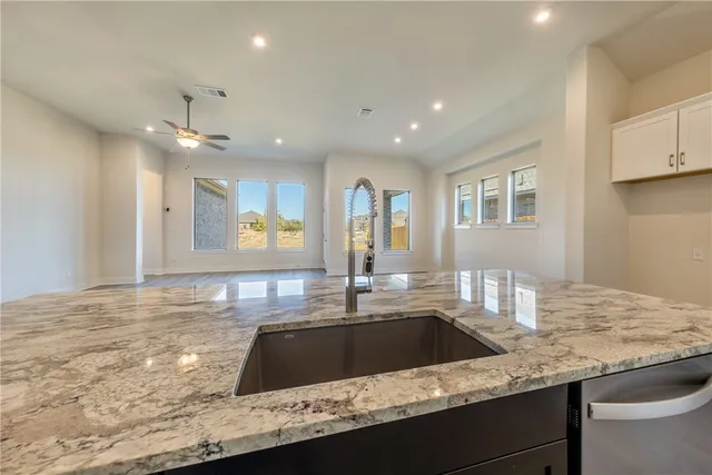 a kitchen with granite countertop counter top space a sink stainless steel appliances and cabinets
