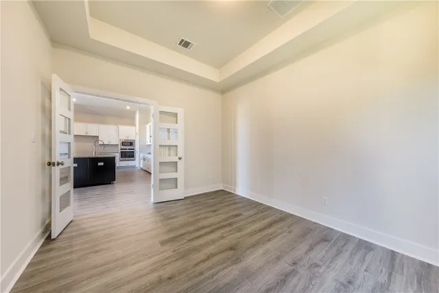 a view of empty room with wooden floor