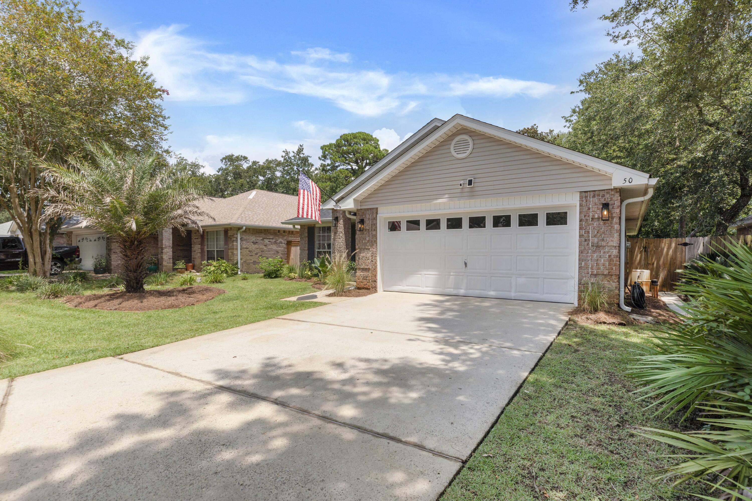 50 Bayou Landing Road Santa Rosa Beach, FL 32459 - Photo 4 of 40 a view of a big house with a big yard and potted plants and large trees