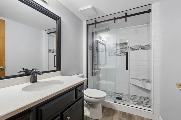 a bathroom with a sink a toilet and shower