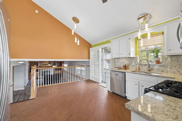 a kitchen with stainless steel appliances granite countertop a sink a stove and a refrigerator