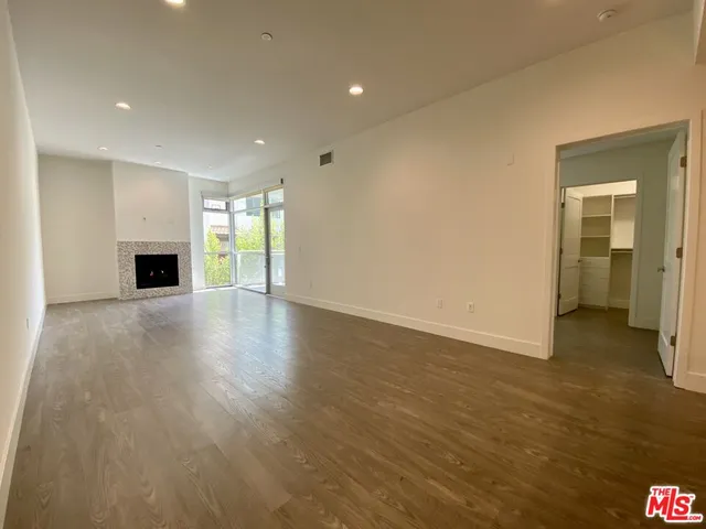 an empty room with wooden floor and fireplace