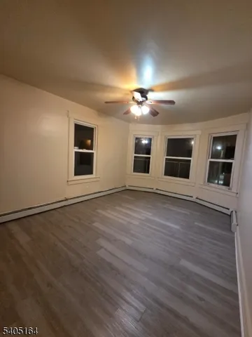 a view of an empty room with a window and fireplace