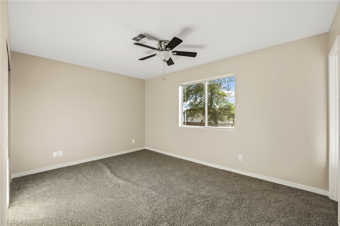 1720 Valencia Road Fort Mohave, AZ 86426 - Photo 29 of 32 Spacious room featuring neutral wall tones, gray carpeting, and a ceiling fan with integrated lighting
