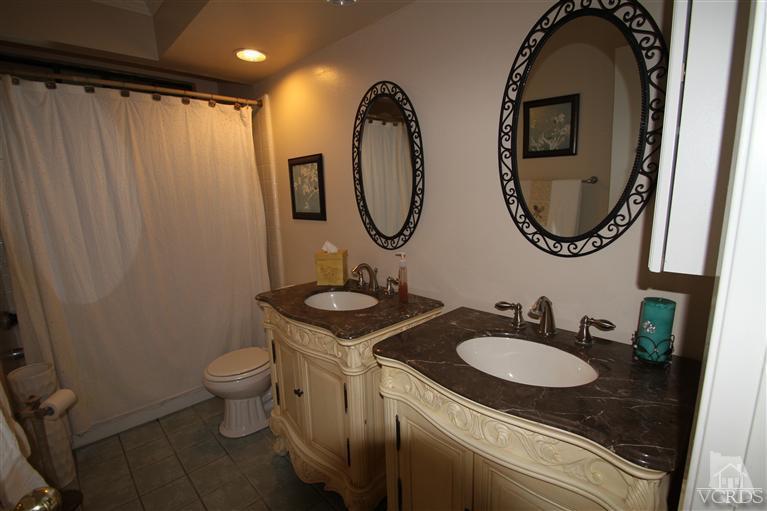 3948 Southhampton Road Moorpark, CA 93021 - Photo 25 of 30 a bathroom with a granite countertop toilet sink and mirror