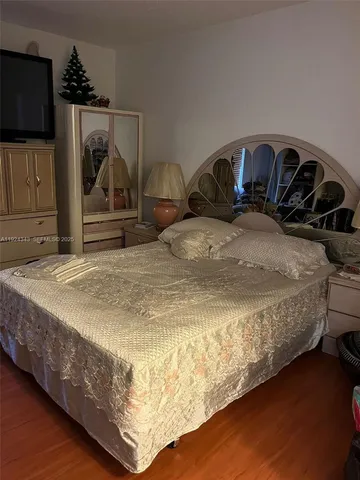 a bedroom with a bed and flat screen tv