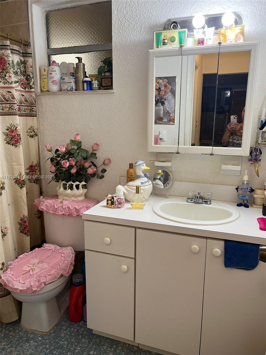 525 West 69th Street, Unit 207 Hialeah, FL 33014 - Photo 12 of 12 a bathroom with a sink mirror and toilet