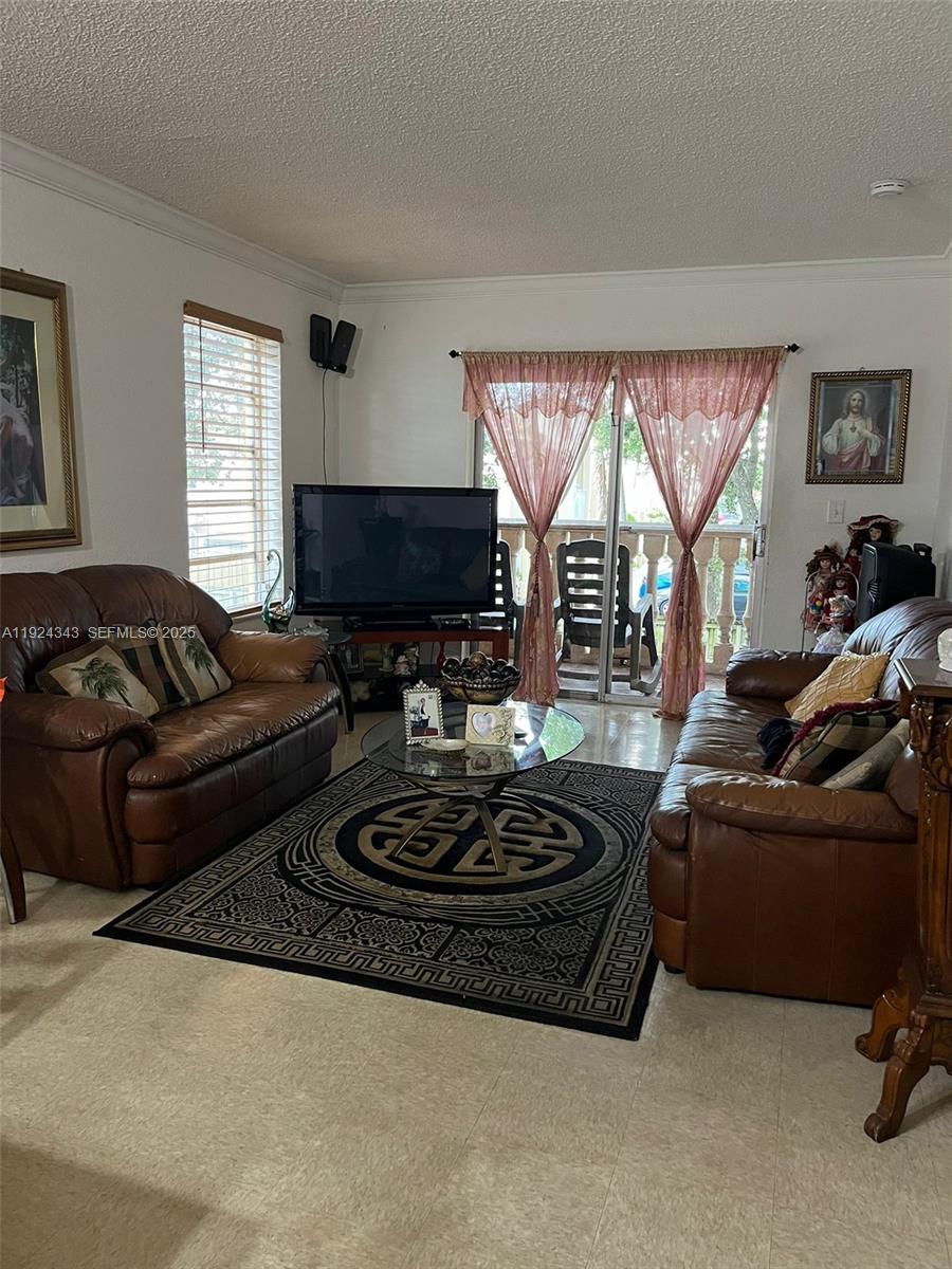 525 West 69th Street, Unit 207 Hialeah, FL 33014 - Photo 3 of 12 a living room with furniture a large window and a flat screen tv