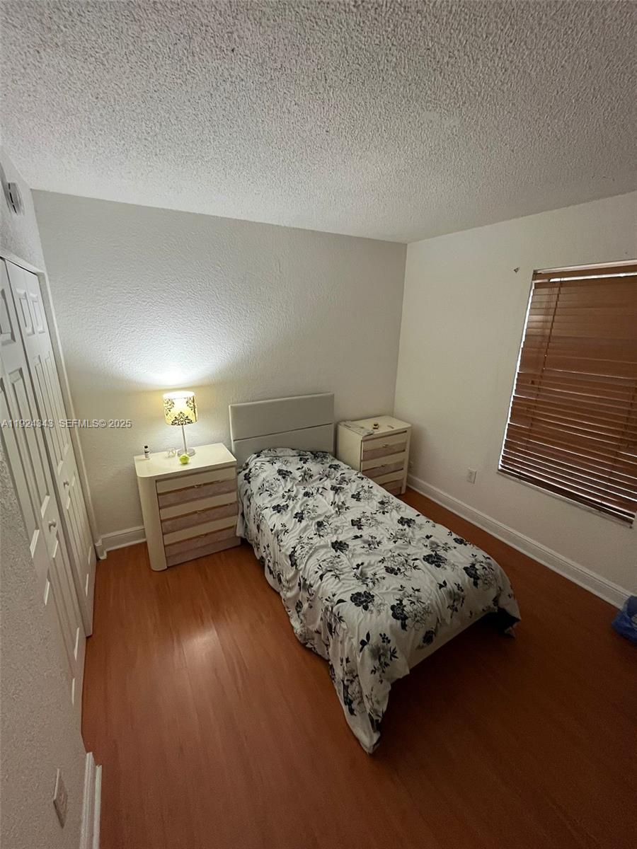 525 West 69th Street, Unit 207 Hialeah, FL 33014 - Photo 9 of 12 a bedroom with a bed and wooden floor