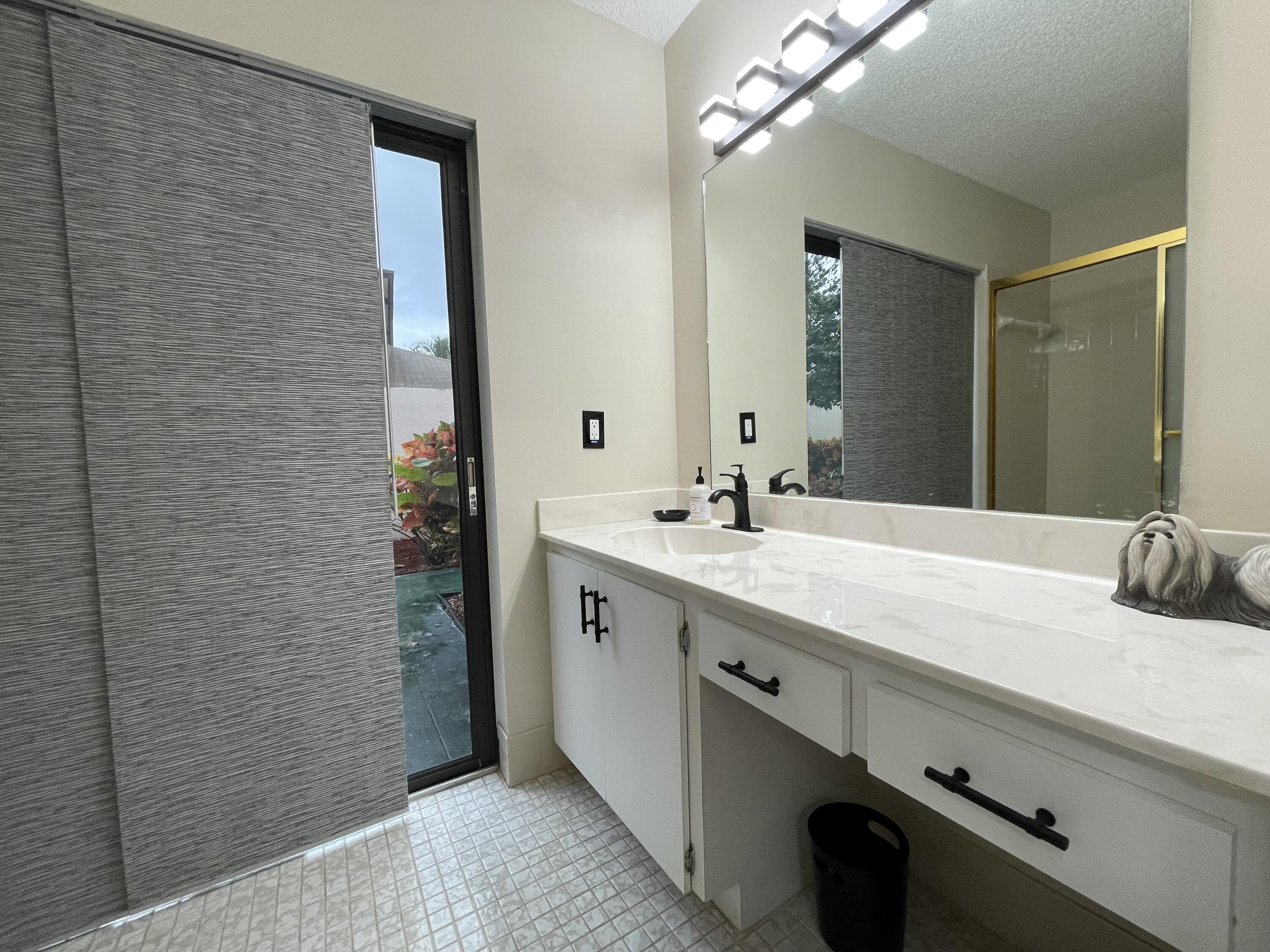 354 Southwest 28th Avenue Delray Beach, FL 33445 - Photo 20 of 54 a bathroom with a double vanity sink a and a mirror