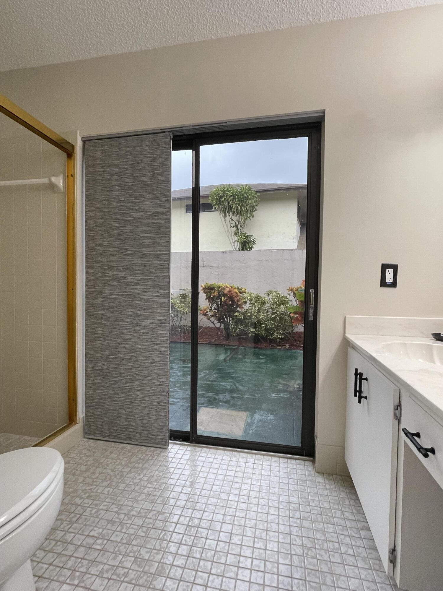 354 Southwest 28th Avenue Delray Beach, FL 33445 - Photo 22 of 54 a bathroom with a glass shower door