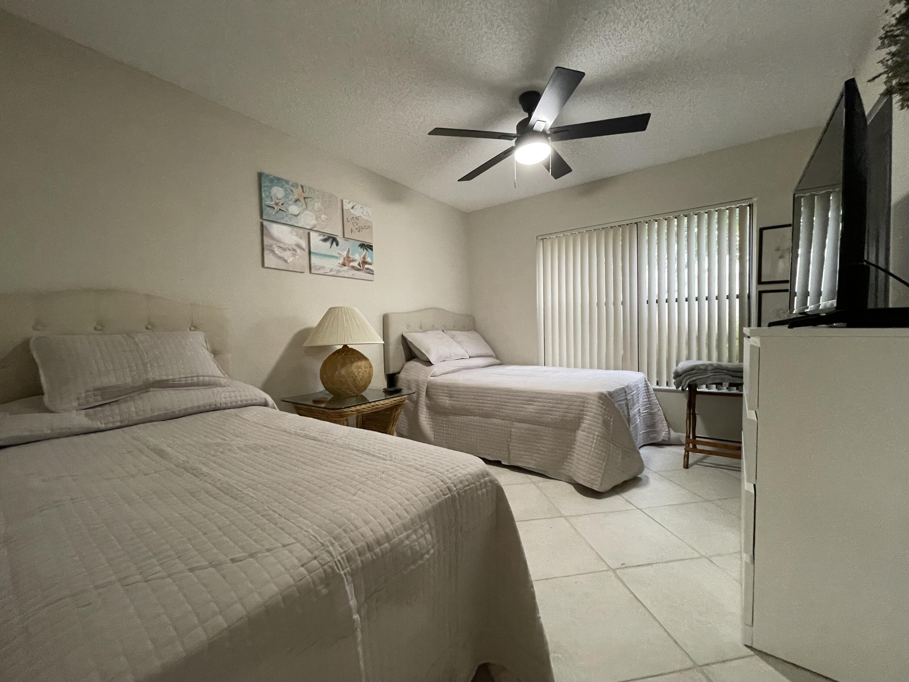 354 Southwest 28th Avenue Delray Beach, FL 33445 - Photo 27 of 54 a spacious bedroom with two beds and a flat screen tv