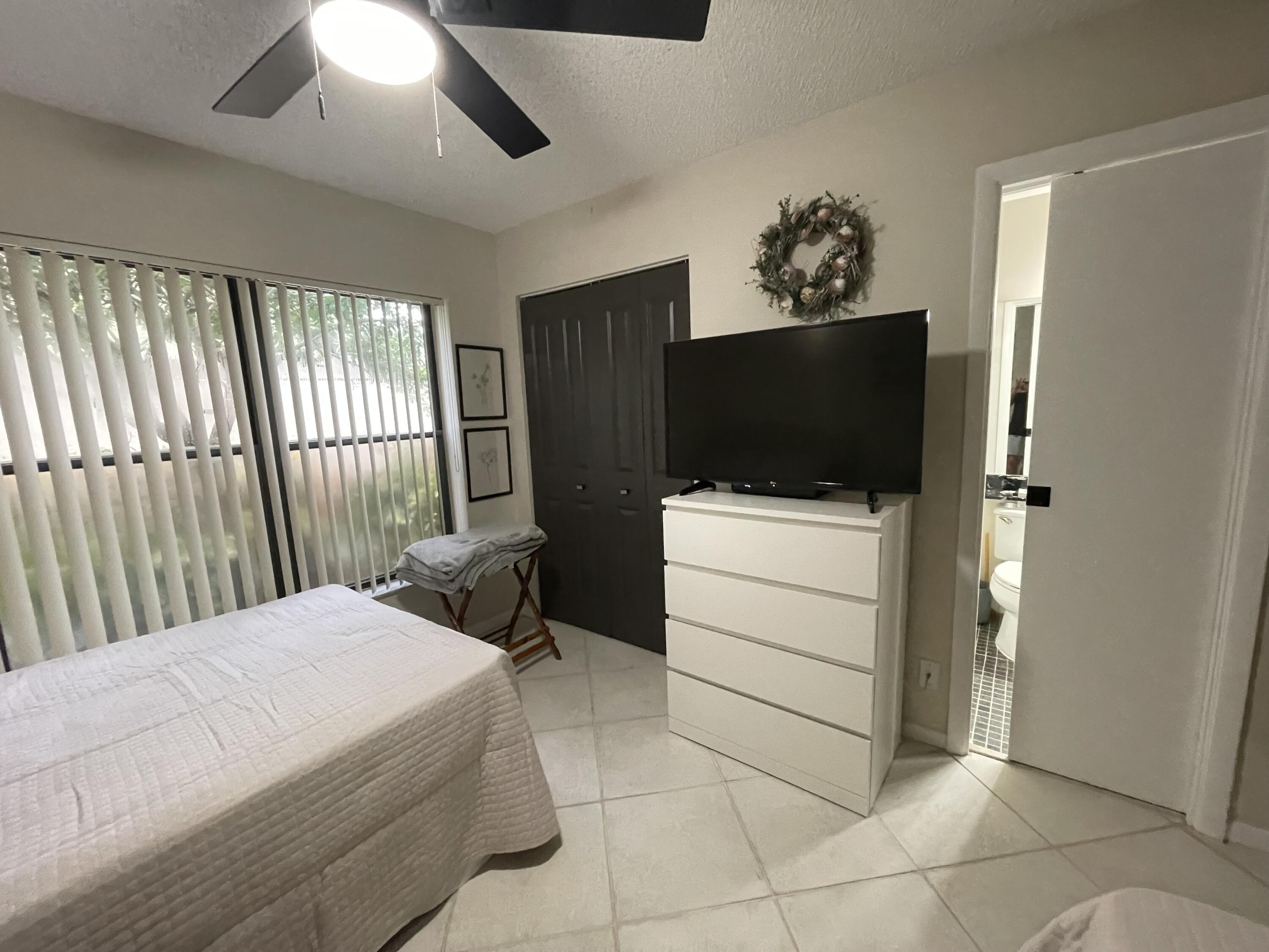 354 Southwest 28th Avenue Delray Beach, FL 33445 - Photo 29 of 54 a bedroom with a bed and a flat screen tv