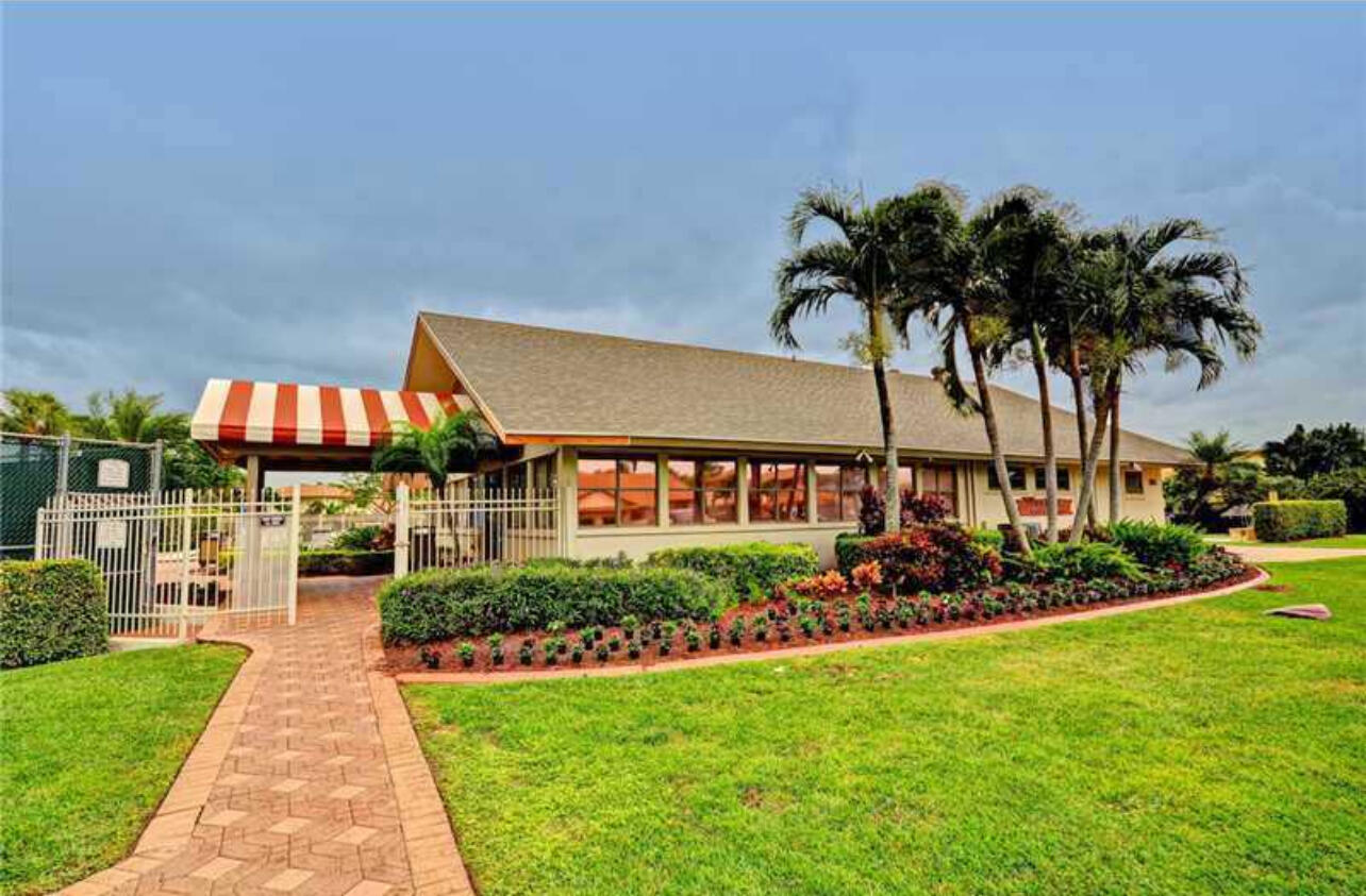 354 Southwest 28th Avenue Delray Beach, FL 33445 - Photo 52 of 54 a front view of a house with a garden and plants