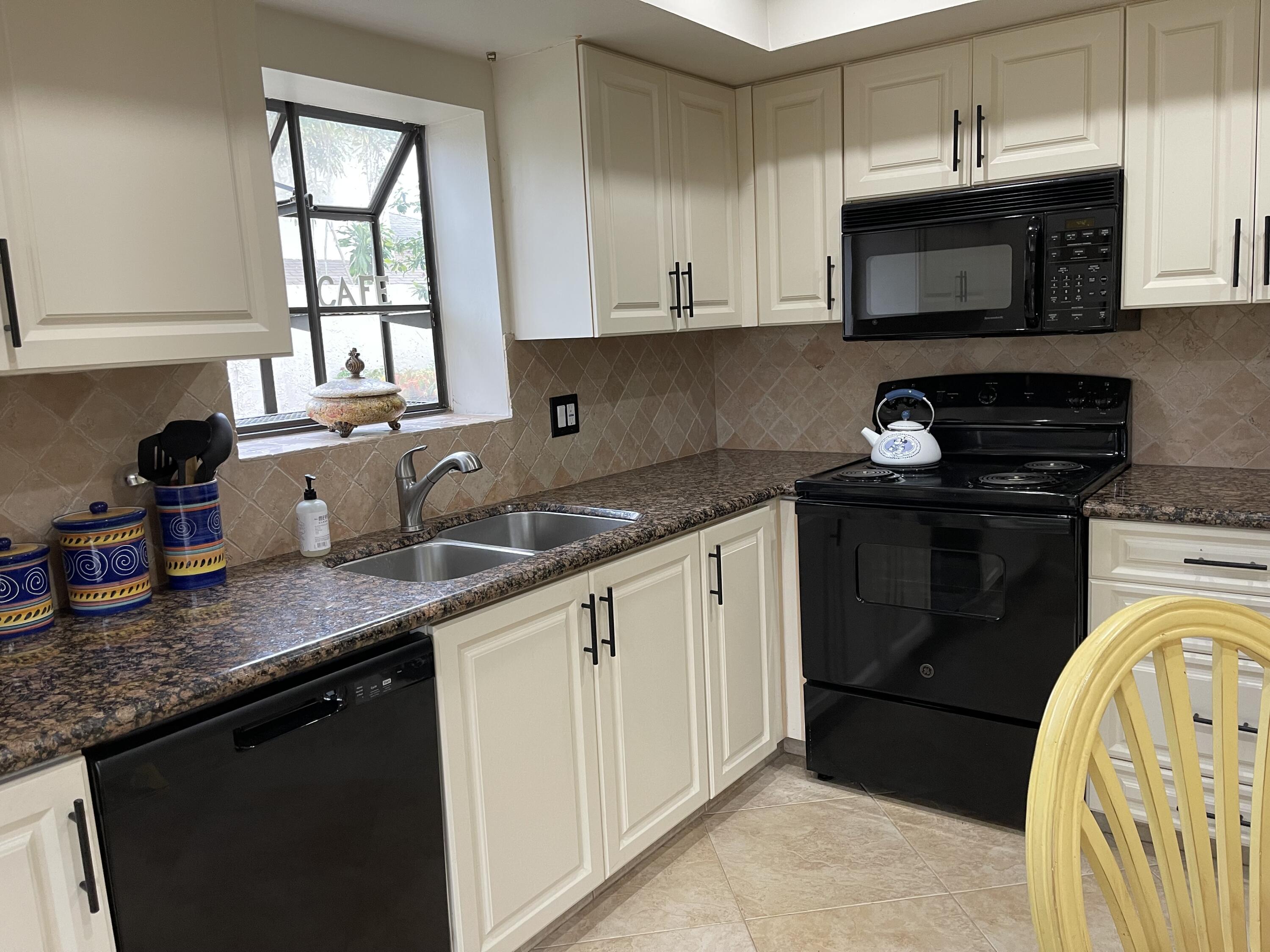 354 Southwest 28th Avenue Delray Beach, FL 33445 - Photo 10 of 54 a kitchen with stainless steel appliances granite countertop a sink a stove a microwave and cabinets