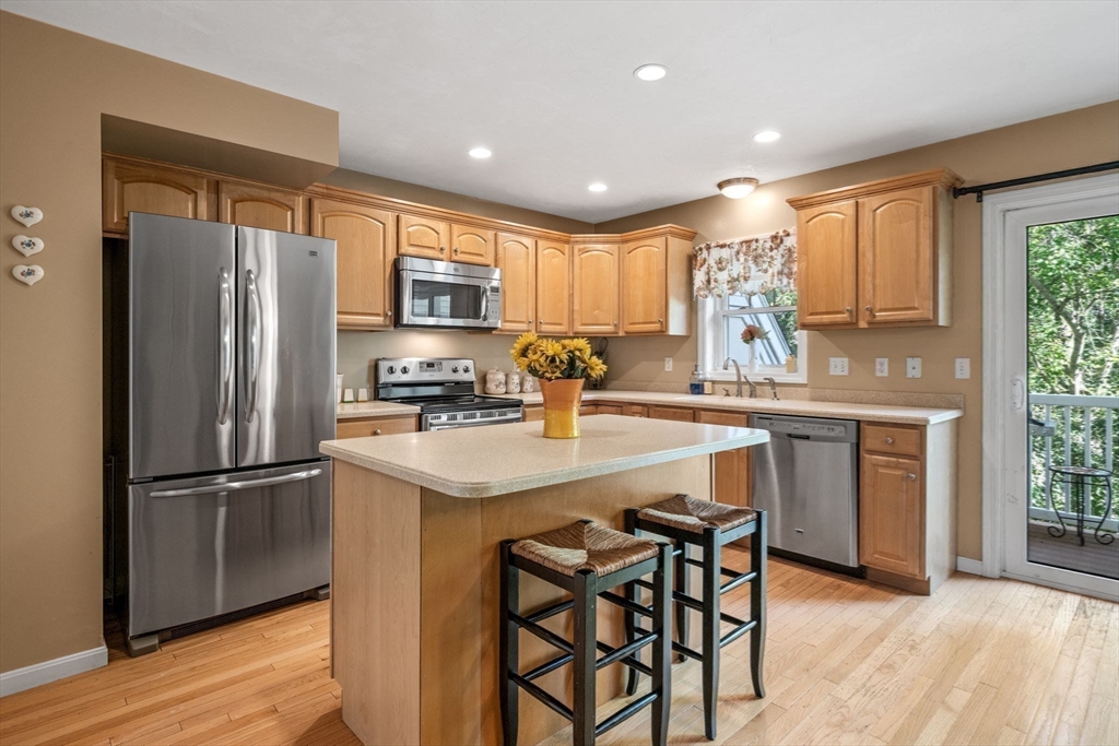 a kitchen with stainless steel appliances granite countertop a refrigerator oven a sink dishwasher and a refrigerator with wooden floor