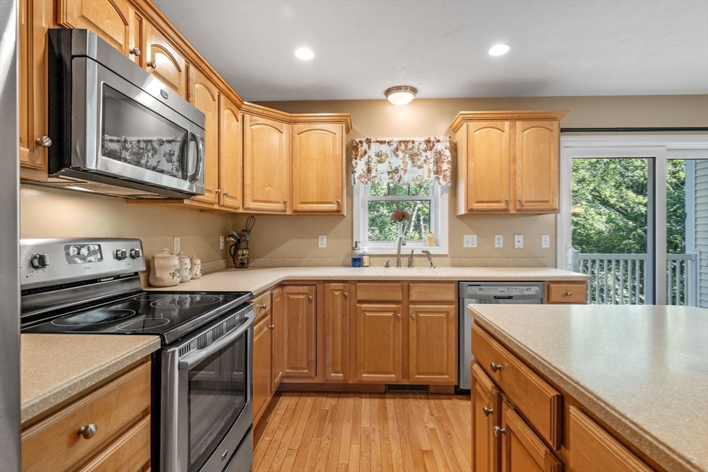 35 Collins Street, Unit 73 Danvers, MA 01923 - Photo 11 of 30 a kitchen with stainless steel appliances granite countertop a stove a sink and a microwave