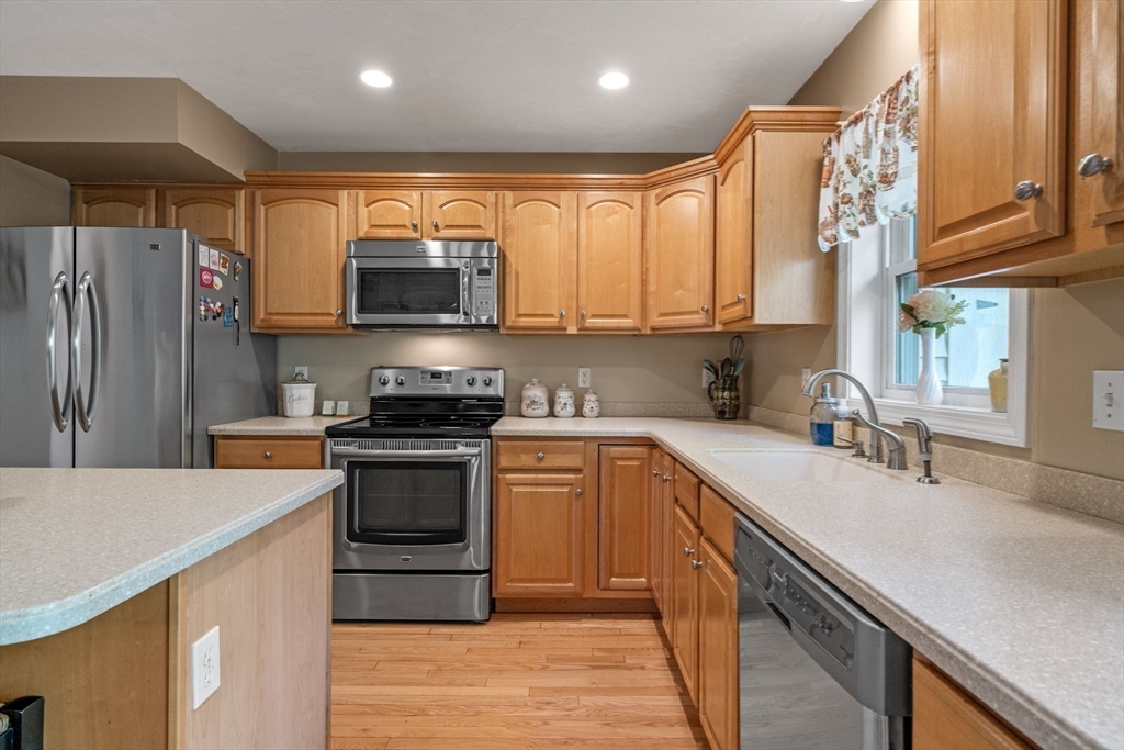 35 Collins Street, Unit 73 Danvers, MA 01923 - Photo 10 of 30 a kitchen with stainless steel appliances granite countertop a stove a sink and a refrigerator