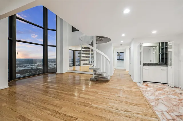 a view of empty room with wooden floor and floor to ceiling window