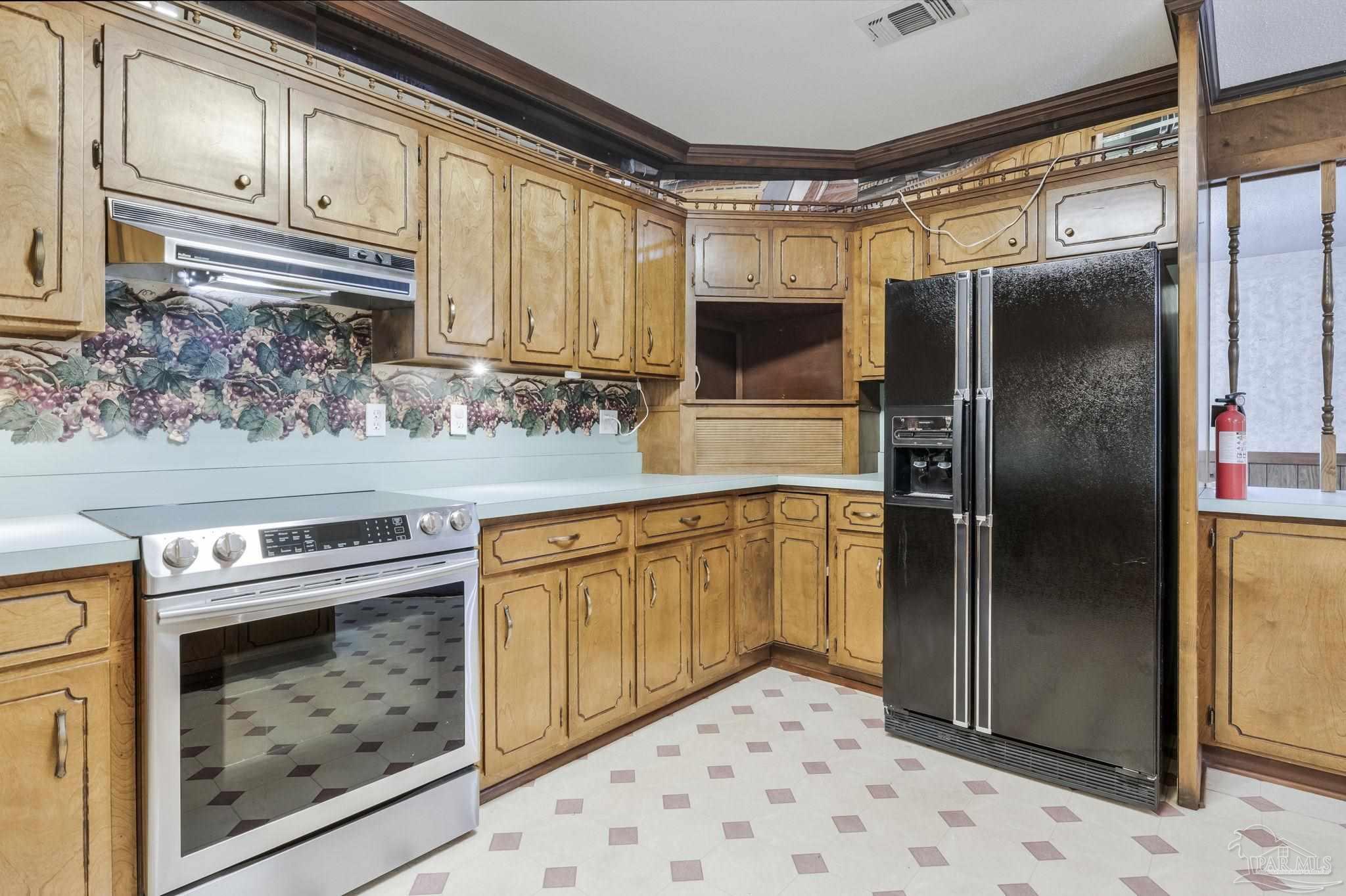 4411 Pace Lane Pace, FL 32571 - Photo 45 of 68 a kitchen with stainless steel appliances granite countertop a refrigerator a stove and a sink with wooden floors