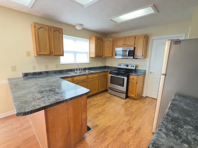 a kitchen with stainless steel appliances granite countertop a sink stove and refrigerator