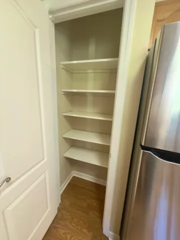 an empty room with wooden floor chandelier fan and windows