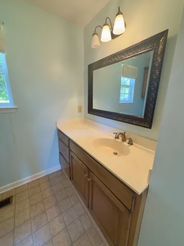a bathroom with a granite countertop sink and a mirror