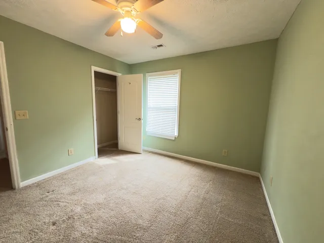 a white toilet sitting next to a white wall