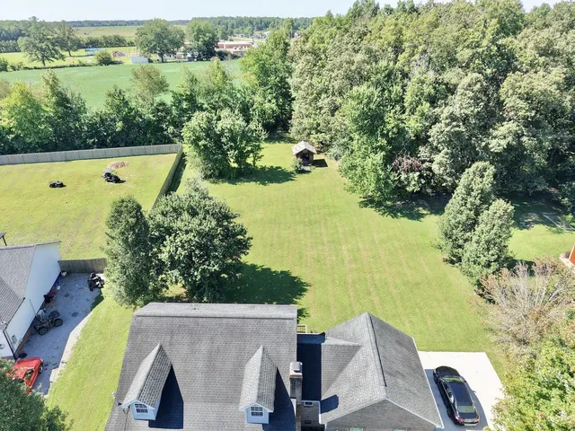 an aerial view of a residential houses with outdoor space and ocean view