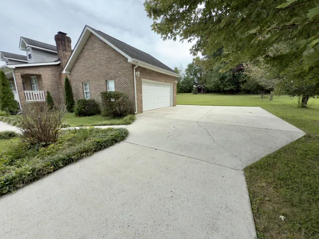 a view of a house with a yard and potted plants