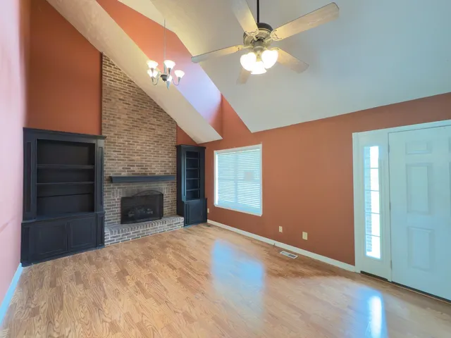 a view of an empty room with a fireplace and a window