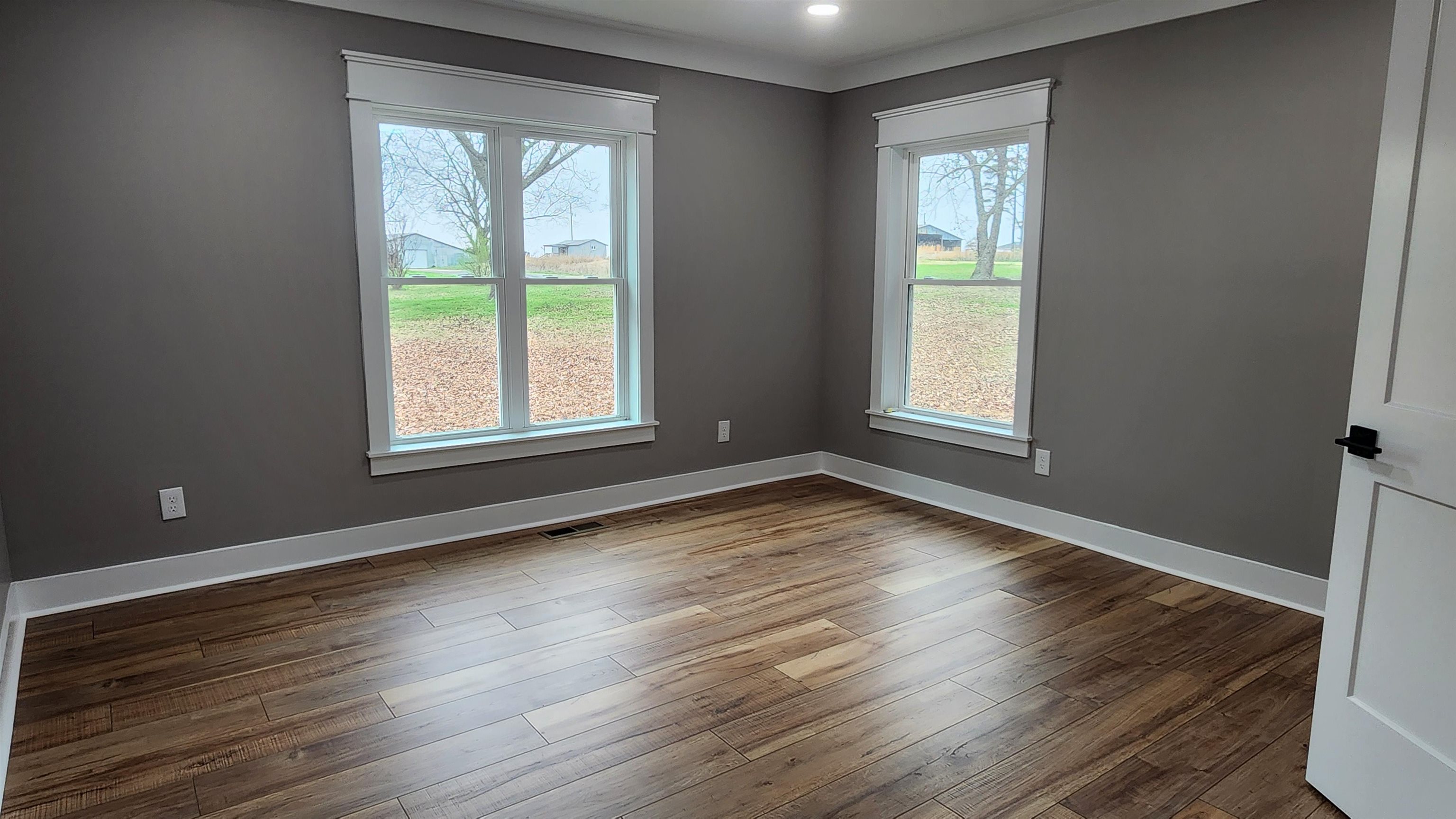 5200 Durhamville Road Ripley, TN 38063 - Photo 7 of 18 an empty room with wooden floor and windows