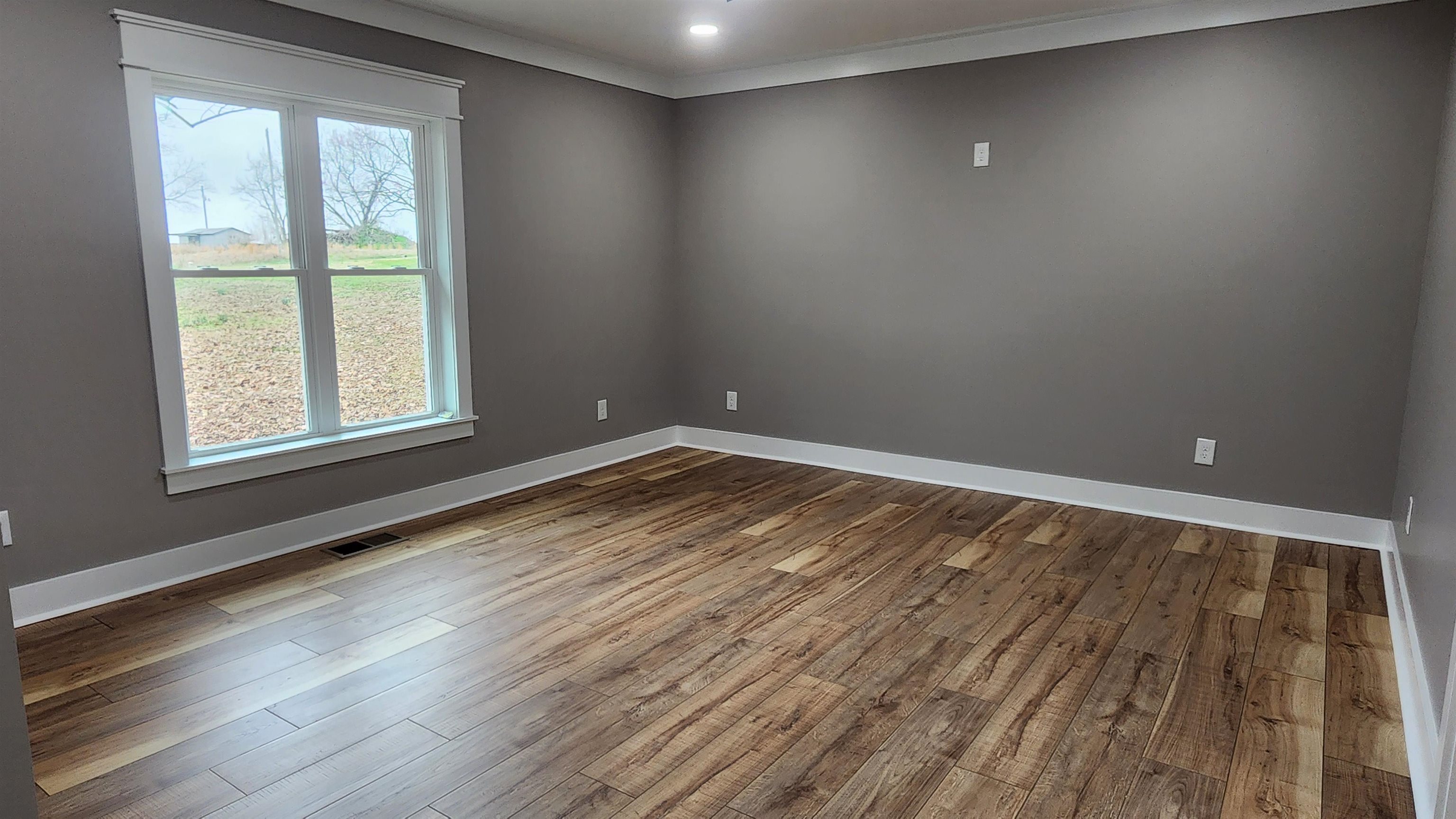 5200 Durhamville Road Ripley, TN 38063 - Photo 8 of 18 an empty room with wooden floor and windows