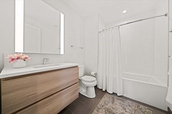 133 Seaport Boulevard, Unit 1017 Boston, MA 02210 - Photo 18 of 28 a bathroom with a sink a toilet and shower