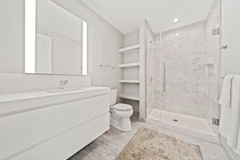 133 Seaport Boulevard, Unit 1017 Boston, MA 02210 - Photo 20 of 28 a bathroom with a bathtub shower sink vanity and toilet