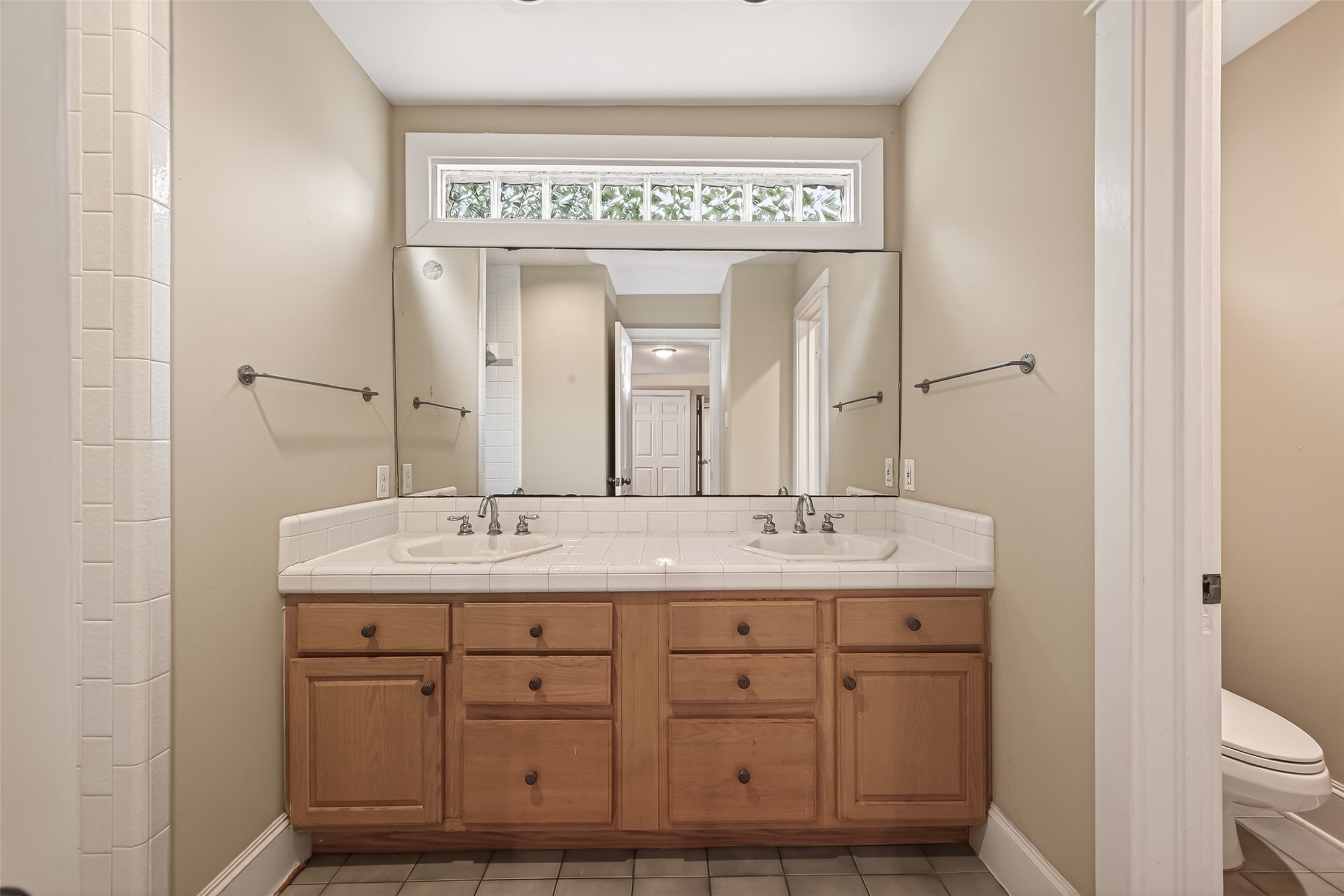 1807 Crocker Street, Unit A Houston, TX 77006 - Photo 21 of 37 a bathroom with a granite countertop sink a toilet and a mirror