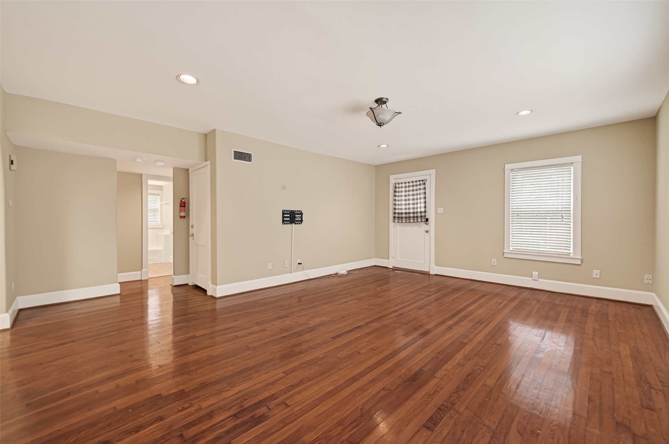 1807 Crocker Street, Unit A Houston, TX 77006 - Photo 6 of 37 a view of an empty room with wooden floor and a window