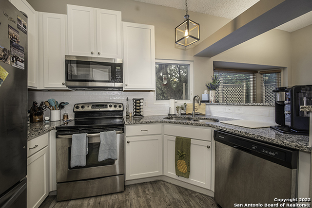 16807 Cedar Tree Way San Antonio, TX 78247 - Photo 3 of 30 a kitchen with stainless steel appliances granite countertop a stove and a microwave