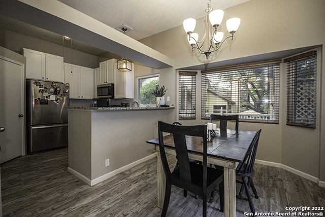16807 Cedar Tree Way San Antonio, TX 78247 - Photo 5 of 30 a kitchen with stainless steel appliances granite countertop a kitchen island hardwood floor and a view of living room