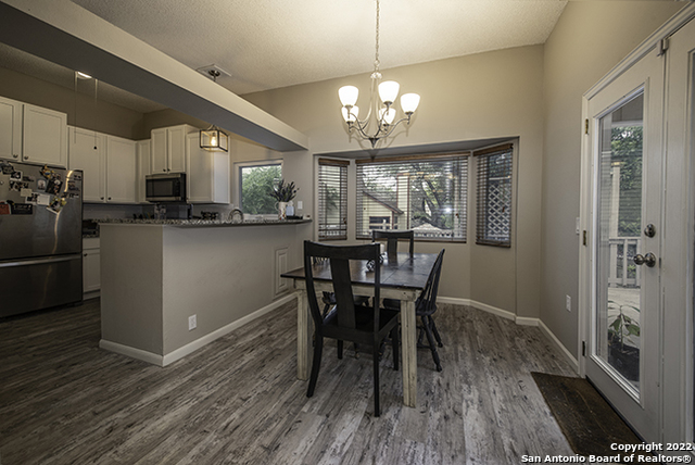 16807 Cedar Tree Way San Antonio, TX 78247 - Photo 6 of 30 a view of a dining room with furniture a chandelier and wooden floor