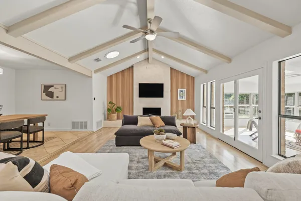a living room with furniture large window and a flat screen tv