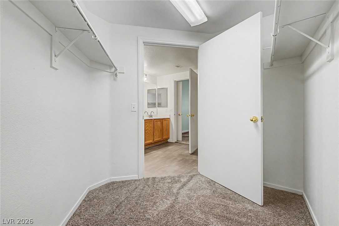 2153 Quarry Ridge Street, Unit 103 Las Vegas, NV 89117 - Photo 25 of 42 A well-organized walk-in closet seamlessly transitions to a bright, functional primary bathroom.