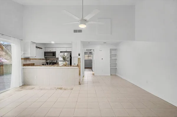 a view of kitchen with stainless steel appliances cabinets and a ceiling fan