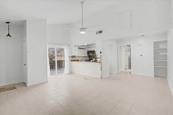 a view of a kitchen with refrigerator and window