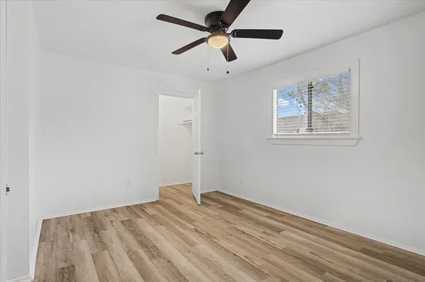 a view of empty room with wooden floor