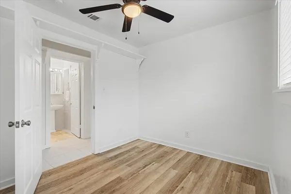 an empty room with a window and a ceiling fan