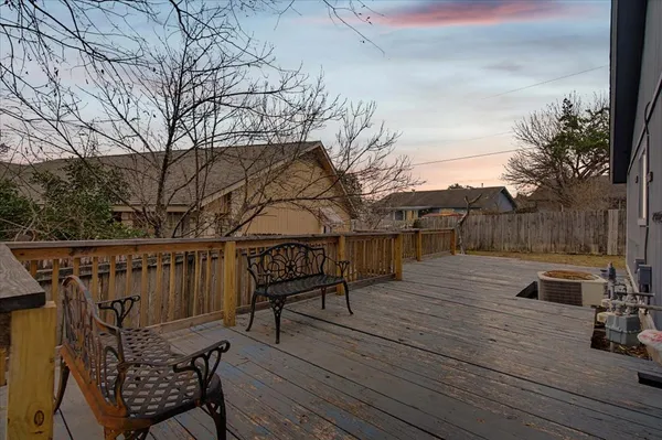 a view of a roof deck with table and chairs with wooden floor and fence