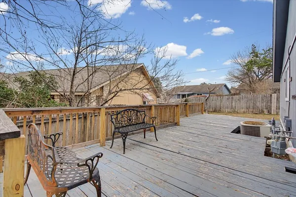 a view of a roof deck with table and chairs a barbeque with wooden floor and fence